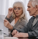 couple sitting at table and looking at bills