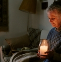 woman sitting on sofa holding large candle jar