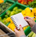 woman with notebook in grocery store