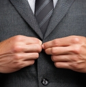 Hands buttoning a suit