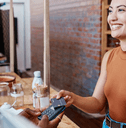 A woman uses her credit card to make a purchase at a cafe.