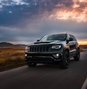 2022 Jeep Grand Cherokee drives on the road at sunset