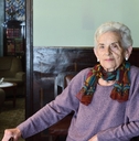 75-year-old woman standing in a dining room