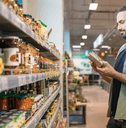 Man looking at an item in his hands while shopping at the grocery store