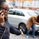 A woman makes a phone call after being in a car accident.