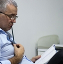 Worried middle-aged businessman having problems at workplace, solving job issues, doing paperwork.