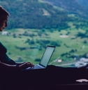 Woman in a scenic location working on a laptop