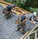 Roofers installing new shingles on a house 