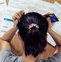 stressed woman holding head worry about bills