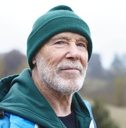 older man outdoors wearing a green beanie