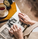 elderly woman looks at the picture in the album