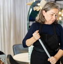 elderly female hairdresser cleaning
