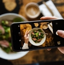 food critic using smartphone to take a photo of their meal