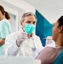 smiling dentist with face mask