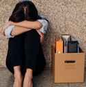 woman hiding her face after being laid off from job