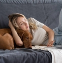 Woman working from home on couch with dog