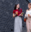 two professionally dressed people walking down street