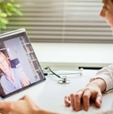 woman using laptop and taking her blood pressure