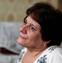 Pensive older woman looking out through window