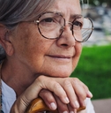 close up of 70 year old woman on sitting on a park bench