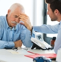 sad worker and younger one talking in office