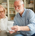 senior couple worried looking at bills