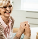 Senior woman holding her spouse's hand and smiling