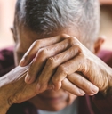 senior man covering his face with his hands