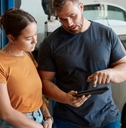 Person talking with a mechanic about the problems with their car