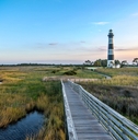 North Carolina outer banks showing lighthouse in background and bridge next to water in foreground