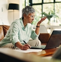 Woman looking confused with laptop and notes