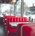 Interior view of a diner with red booths and stools