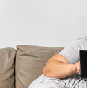 person on couch using tablet device