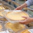 A shopper getting a pie from the grocery store