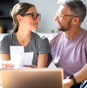 Happy couple looking at each doing paperwork