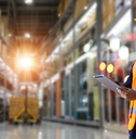trader worker in orange vest and hardhat in a warehouse