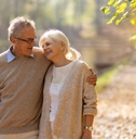 retired couple walking in autumn park