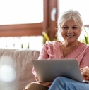 senior couple on couch with laptop