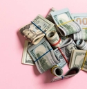US Dollar bills bundles on pink background