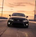 black lexus is driving in city at sunset