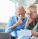 Worried older couple looking at bills