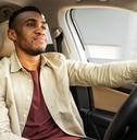 Man driving car with tan leather interior
