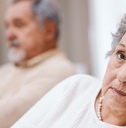 Bored senior woman looking while husband is in the back