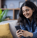 Woman sitting on couch scrolling on cell phone