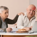 Older retired couple looking worried about bills