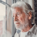 contemplative older man looking out window
