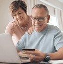Older couple on laptop using credit card