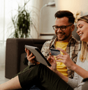 Couple using credit card on tablet