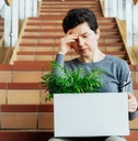 Woman with box of personal items sitting alone on the staircase after being laid off from job