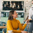 Woman using credit card at restaurant